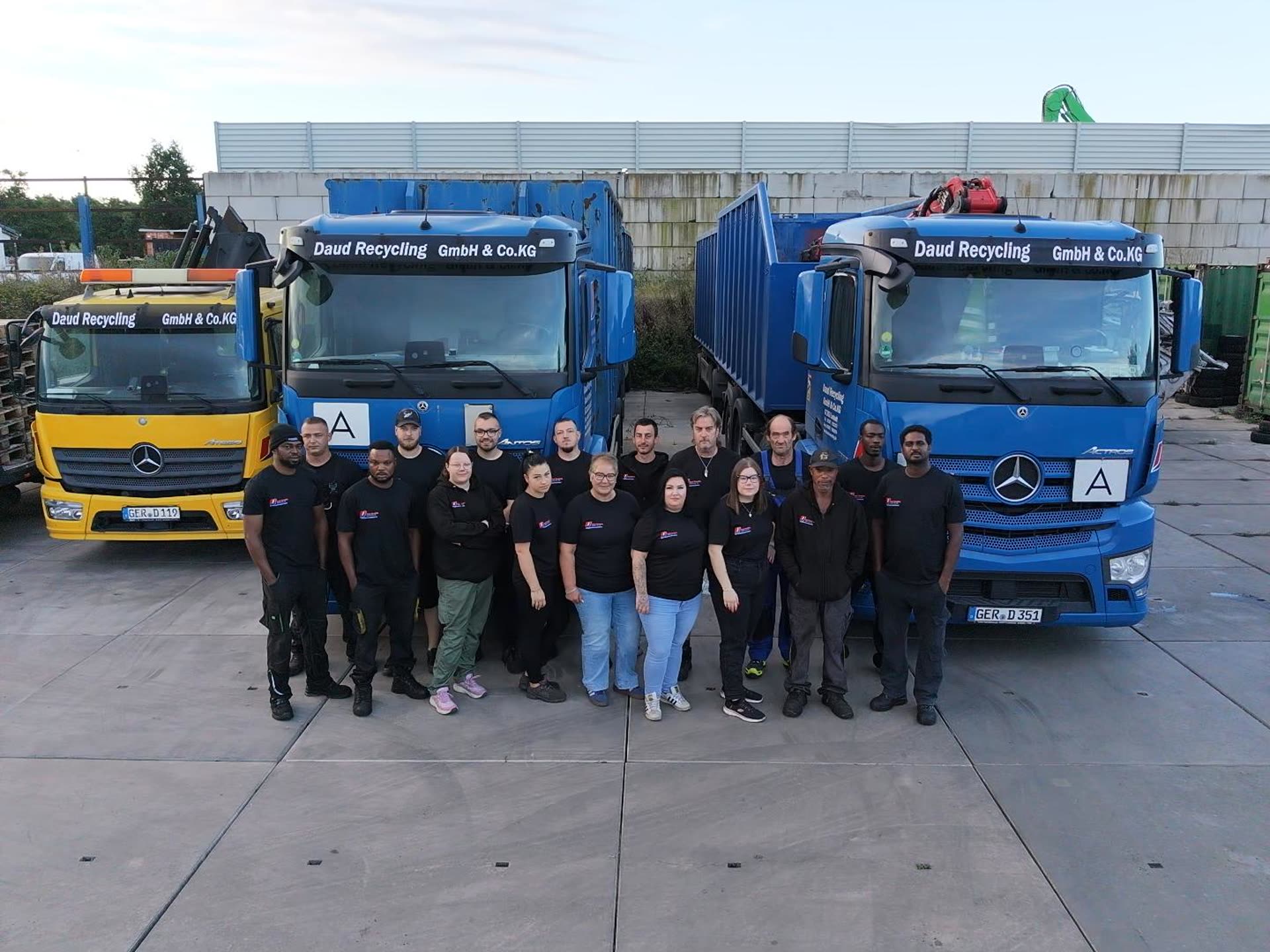 Das Team von Daud Recycling vor den Firmenfahrzeugen